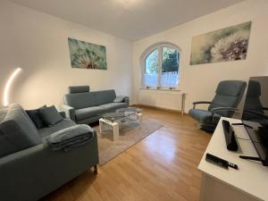 a living room with two couches and a table at Charmante, ruhige Erdgeschosswohnung mit Balkon in Lüdenscheid