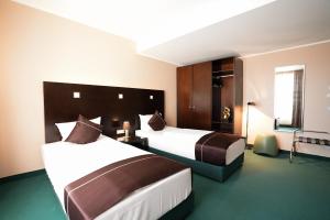 a hotel room with two beds and a window at Hotel Lumière an der Messe in Frankfurt/Main +102 photos