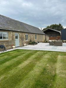 a backyard of a house with a grass yard at High Shilford Barn in Ridingmill