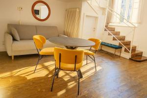 una sala de estar con una mesa, sillas y un sofá en Isola nell'Isola apt -Isola e Garibaldi, en Milán 4 fotos más