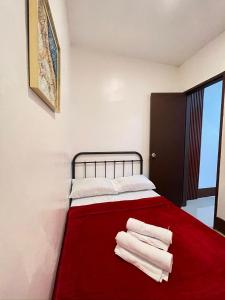 a bedroom with a red bed with towels on it at J&L Apartment 
