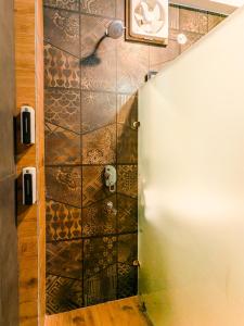 a shower in a room with a tile wall at Heavenly Retreat, Shangarh in Shangarh +45 photos