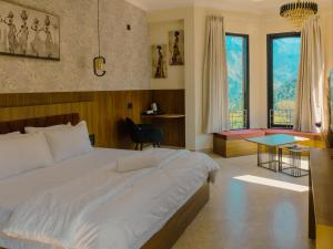 a bedroom with a large white bed and a desk at Heavenly Retreat, Shangarh in Shangarh