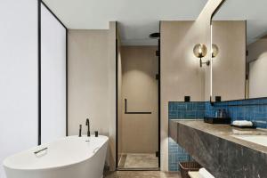 a bathroom with a tub and a sink at Four Points by Sheraton Guiyang Huaxi Park in Guiyang