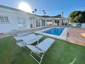 ミハスにあるVilla Mimosaの芝生の椅子とスイミングプール
