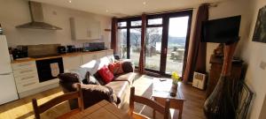 a living room with a couch and a table at Wastwater Cottage on The Big "W" Ranch in Seascale