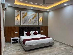 a bedroom with a bed with four paintings on the wall at The food villa in Gaushala