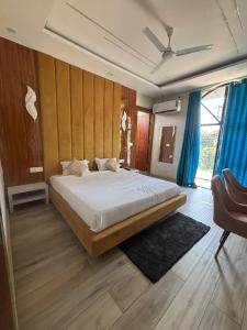 a bedroom with a large bed with blue curtains at The food villa in Gaushala