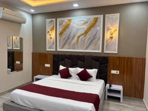 a bedroom with a large bed with three paintings on the wall at The food villa in Gaushala