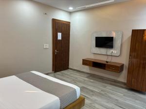 a bedroom with a bed and a tv on the wall at The food villa in Gaushala