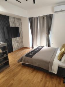 una camera da letto con un letto grande e una TV a schermo piatto di Sky view N&N a Skopje