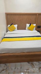 a bed with yellow and blue pillows on it at krishna residency in Mathura