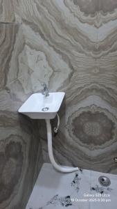 a white sink on a stone wall in a bathroom at krishna residency in Mathura +7 photos