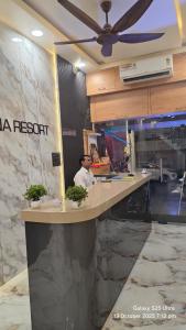 a man sitting at a reception desk in a lobby at krishna residency in Mathura