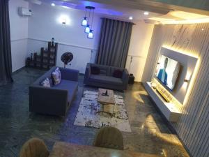 a living room with two couches and a television at Peters 3 Bedrooms Duplex Service Apartment in Lekki