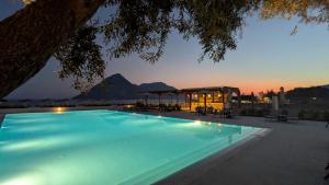 a swimming pool with a view of a mountain at Costa Ionica · Mytikas Seaside Hotel in Mýtikas