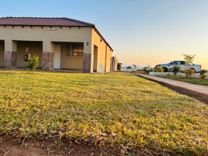 a house with a large yard in front of it at Rooibok Gardens in Mokopane