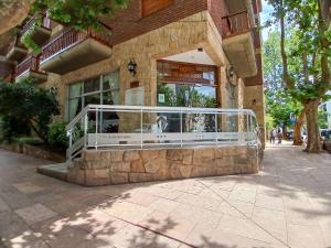 a store front with a white railing in front of a building at Hotel 30 de Octubre in Mar del Plata