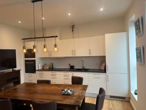 a kitchen with a wooden table and a kitchen with white cabinets at 37-2-4 Dæmningen in Vejle
