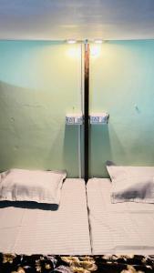 a room with two beds in a room with a wall at REST POINT Dormitory in Jaipur +12 photos
