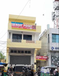 a first point building with cars parked in front of it at REST POINT Dormitory in Jaipur