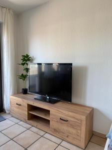 un téléviseur à écran plat posé sur un centre de divertissement en bois dans l'établissement Schöne Wohnung mit Balkon und Parkplätze, à Lünen