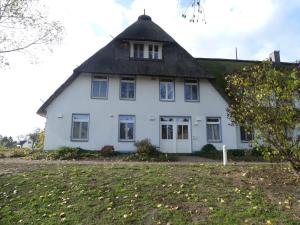 a large white house with a thatched roof at Landhaus am Haff A3 in Stolpe auf Usedom