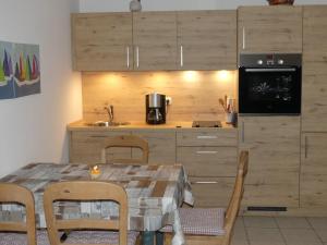 a kitchen with a table with chairs and a microwave at Landhaus am Haff A3 in Stolpe auf Usedom +21 photos