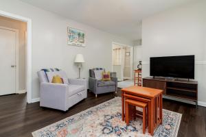a living room with a tv and two chairs and a table at Dual-Family Retreat Sunlit Haven in Columbus