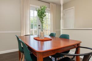 a dining room with a wooden table and green chairs at Dual-Family Retreat Sunlit Haven in Columbus