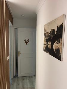 un pasillo con una puerta y una pintura en la pared en Le Refuge du Cerf, en Bouillon