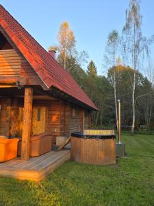 a log cabin with a deck in the yard at Tammetalu puhkemaja 
