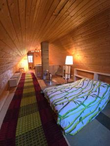 a large bed in a room with a wooden ceiling at Tammetalu puhkemaja 