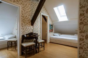 a bedroom with two beds and a table and a window at Allegro Hotel in Ljubljana