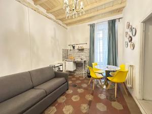 a living room with a couch and a table and chairs at Elegant Apartments Steps from the Colosseum in Rome
