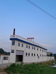 a large white building with a garage at VnM Paradise in Chunār