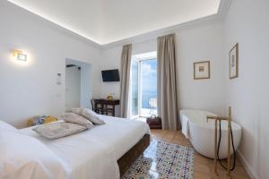 a bedroom with a bed and a tub and a window at Dimora de Feo in Amalfi