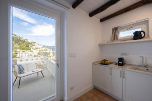a kitchen with a sliding glass door leading to a balcony at Dimora de Feo in Amalfi