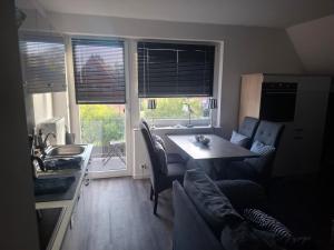 a kitchen with a table and chairs and a kitchen with a window at Himmelhoog in Emden