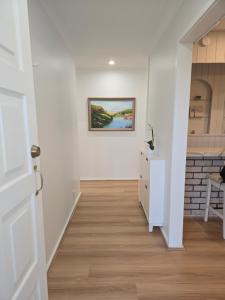 The Greenview Luxe Home - Hornsby في هورنسبي: مدخل بجدران بيضاء ولوحة على الحائط