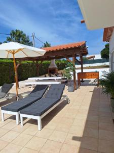 a group of lounge chairs and umbrellas on a patio at Villa Flavia in Aljezur
