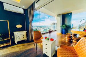 Habitación con escritorio, sillas y ventana grande. en Homestay Osaky view biển, en Vung Tau