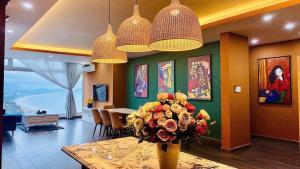 Un comedor con una mesa con un jarrón de flores. en Homestay Osaky view biển, en Vung Tau