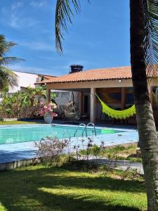 a villa with a swimming pool next to a house at Sitio Damiana in Paracuru