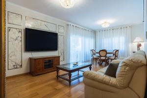 un salon avec un canapé et une télévision à écran plat dans l'établissement Beachfront Luxury Living Limassol, à Limassol