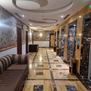 Un salón con un vestíbulo con un sofá y una mesa. en Durrat Al Talae Hotel, en Al Masfalah