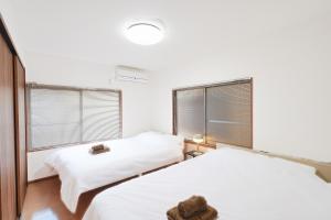 duas camas em um quarto com duas janelas em Monthly Only Kotori Akasaka Ideal Place for Long-term Stay and Workcation em Tóquio