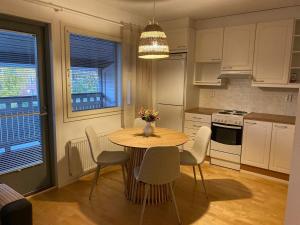 eine Küche mit einem Holztisch und Stühlen sowie eine Küche mit einem Tisch in der Unterkunft Valoisa saunallinen luhtitalokaksio Joupista in Seinäjoki + 2 Fotos