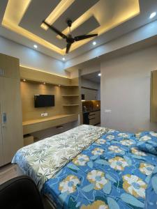 a bedroom with a bed with a blue and white comforter at Infinity Haven in Greater Noida