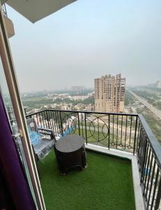 a balcony with a table and a view of a city at Infinity Haven in Greater Noida